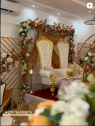Fauteuils d'honneur devant une décoration florale et dorée